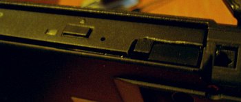 another image of correct position with 1mm space between drive and upper side of NB, you can see what was need to remove from front cover of tray (on it's right side) to make drive possible to insert 1-2mm deeper to set in correct position in Ultrabay 2000 slot and click and be finally strongly in position without fear of ejecting whole drive at ejecting of tray, original IBM front cover of tray isn't compatible with new drive front cover holes and eject button has different position too